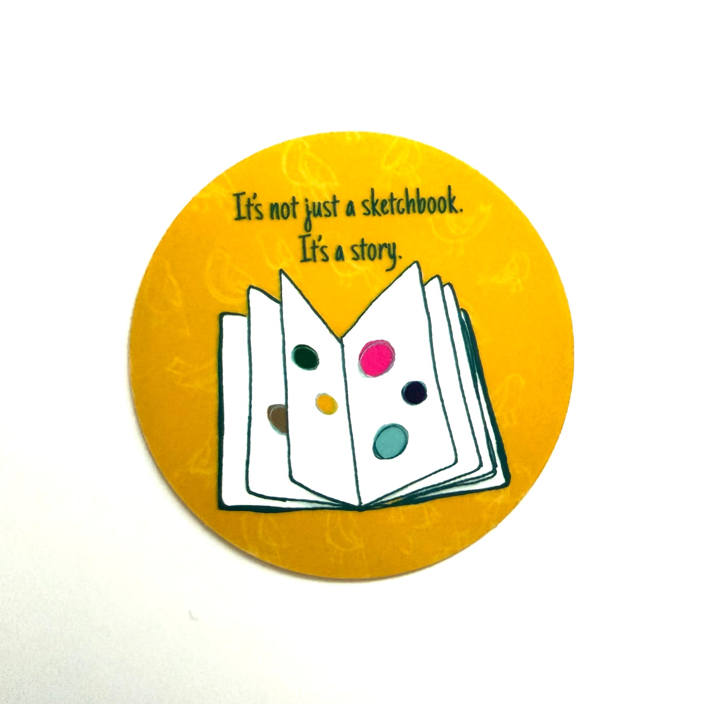 Round sticker with an open book illustration and text on a yellow background