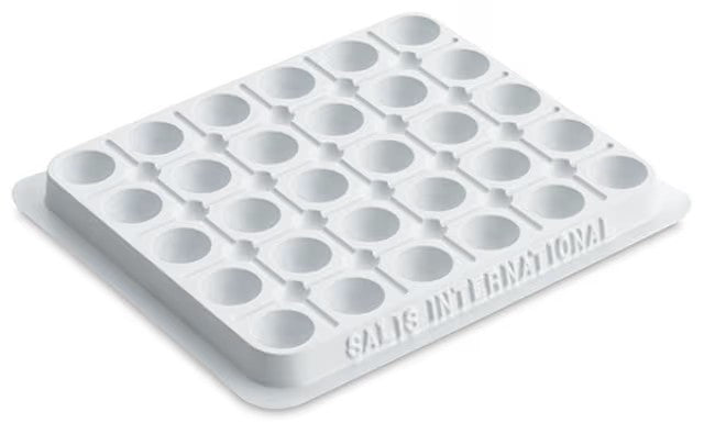 White plastic paint palette with 30 wells on a white background
