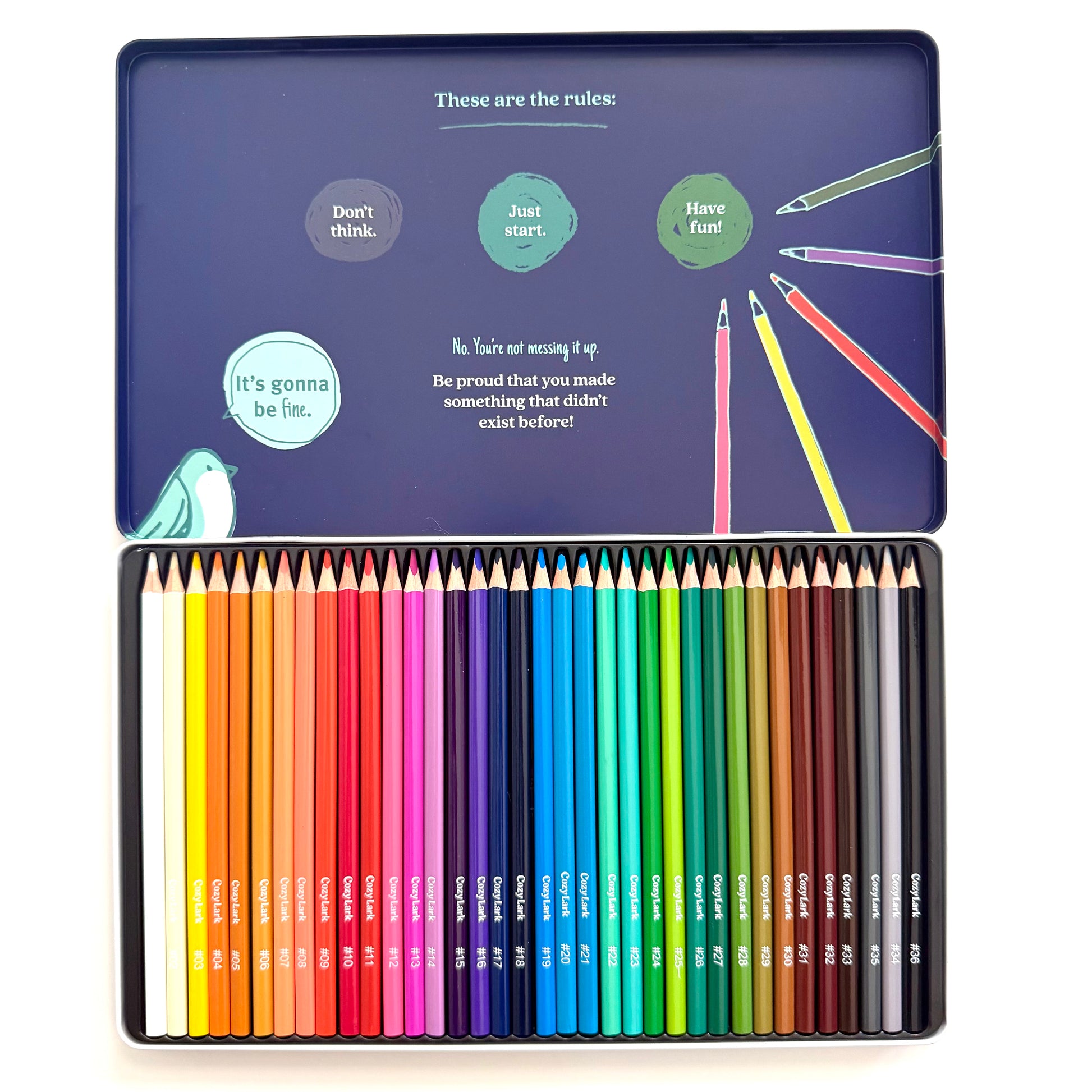 A 36-piece colored pencil set in a square metal tin, shown open against a white background. The top lid features a dark blue background with whimsical illustrations and text, while the bottom tray displays the neatly arranged colored pencils in a rainbow of shades.
