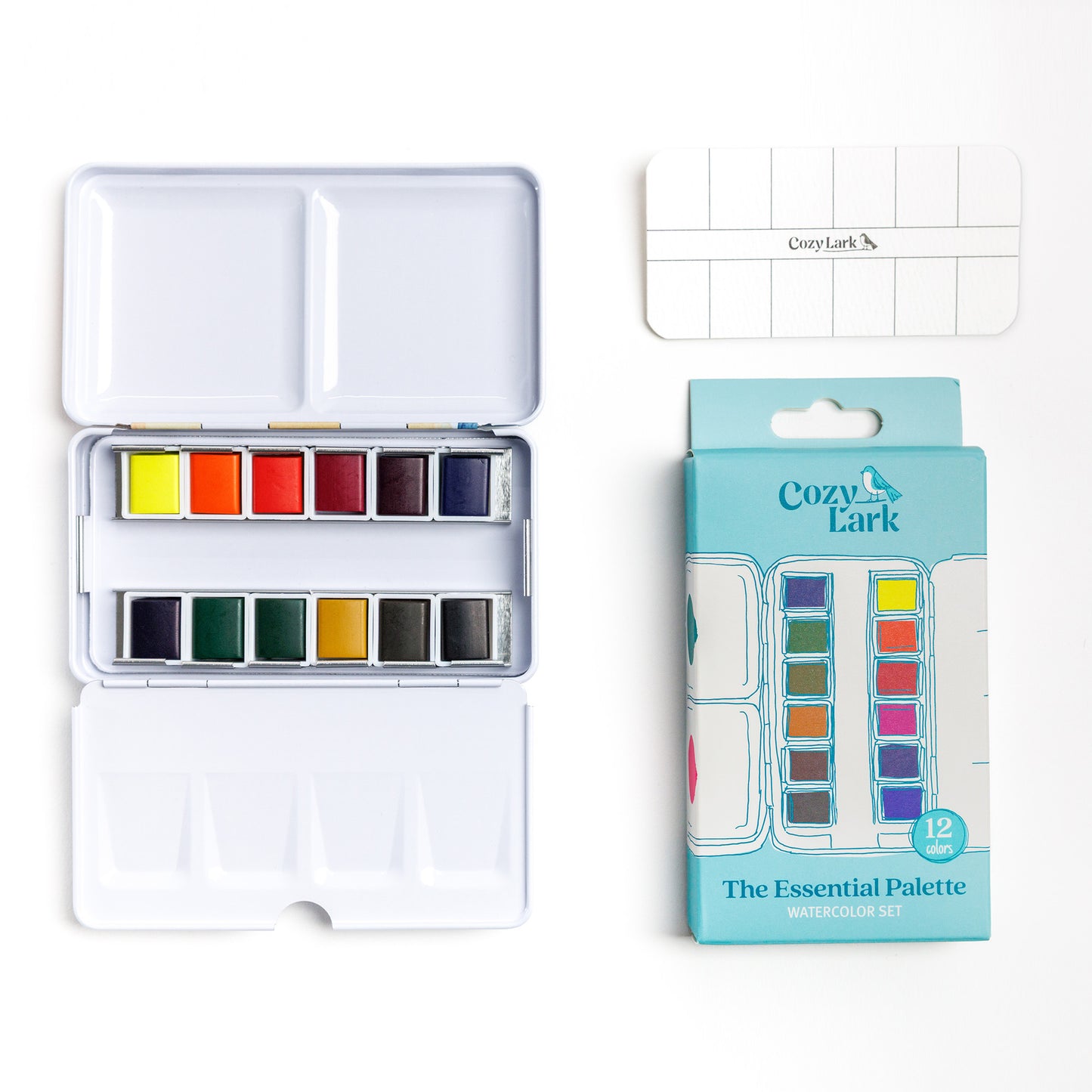 Cozy Lark Essential Palette 12‑color watercolor set with open tin of pans, blank swatch card, and  box on white background