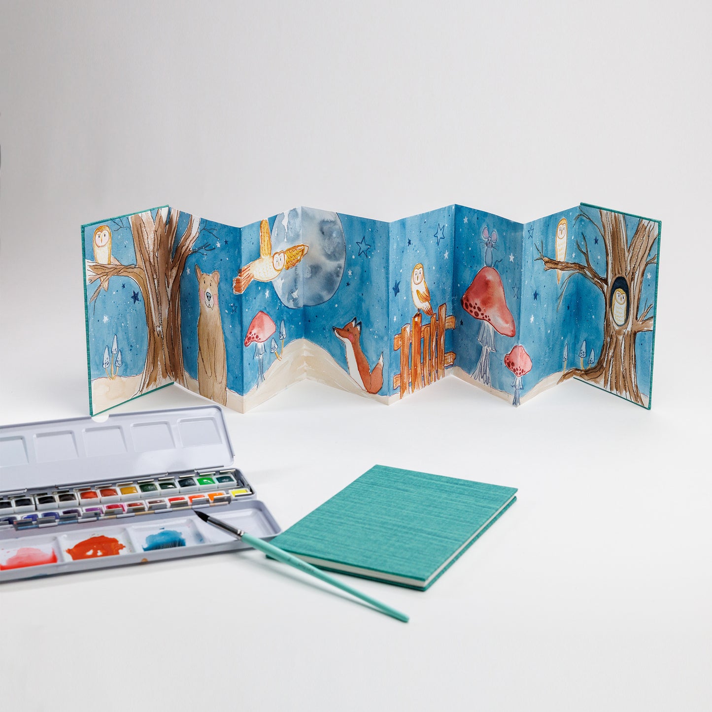 Sample of painted accordion book with closed book, 24-color watercolor palette and Size 8 Round brush