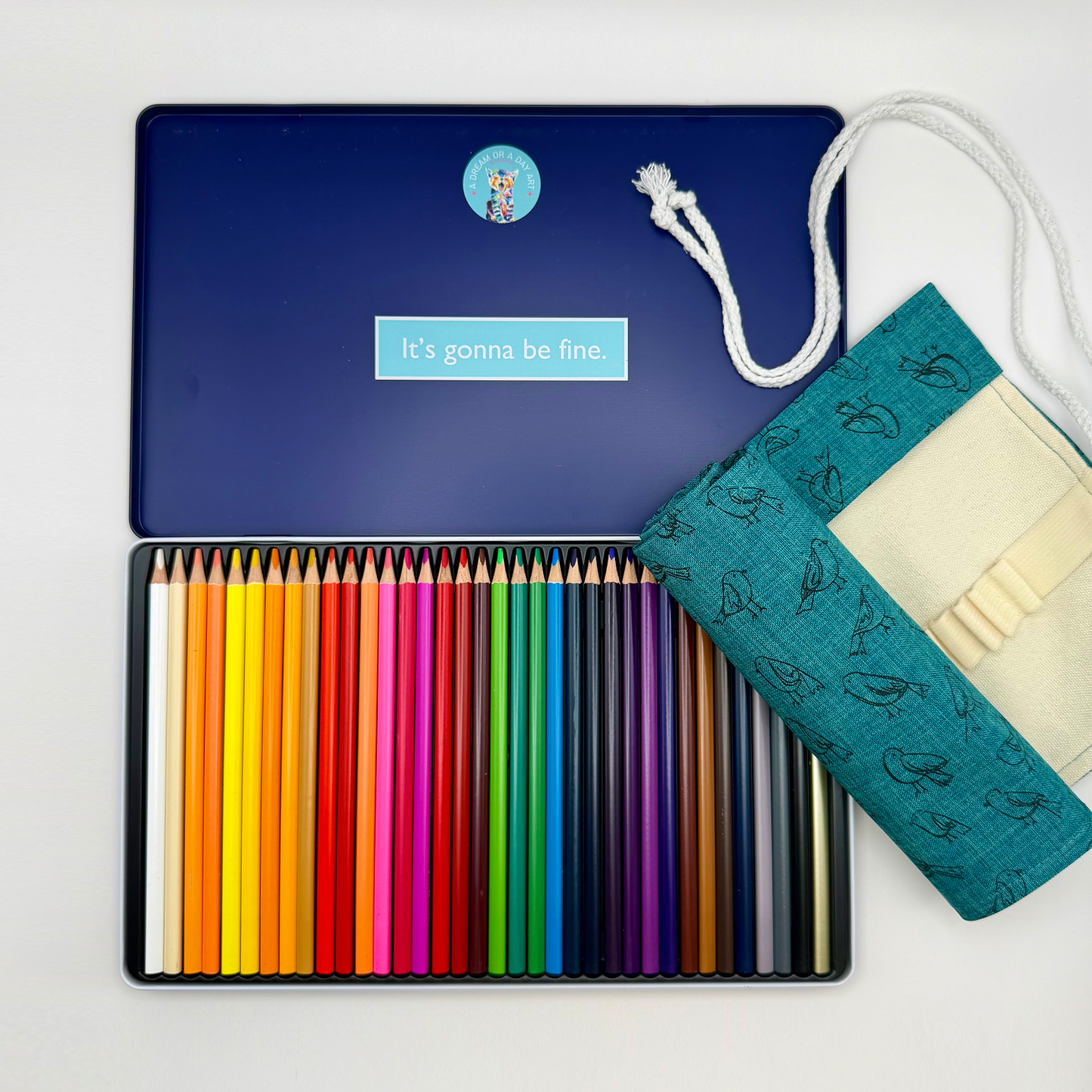 Open colored pencil tin featuring 36 colors and  canvas pencil roll with printed bird pattern.
