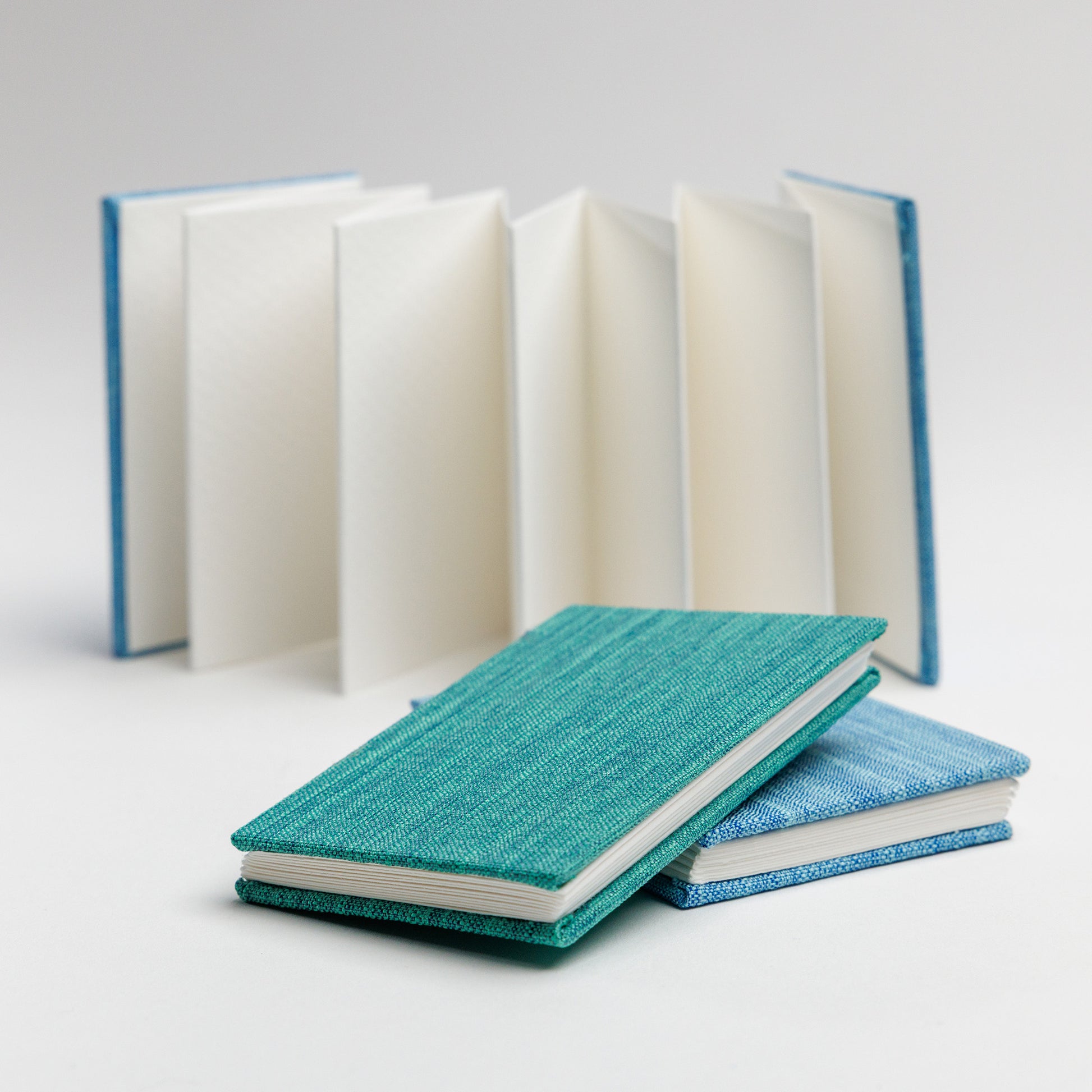 Open accordion book in background with set of two accordion mini books stacked in the foreground