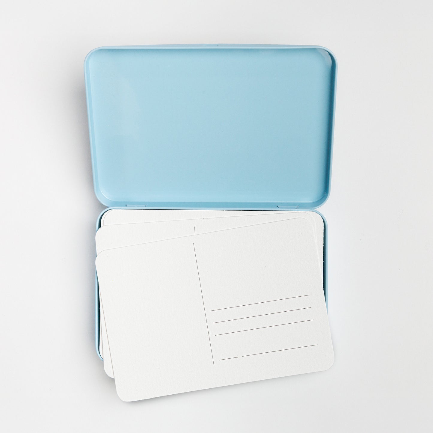 Open postcard tin with blank postcards inside.