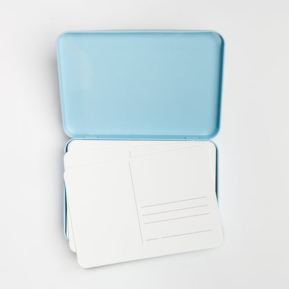 Open postcard tin with blank postcards inside.
