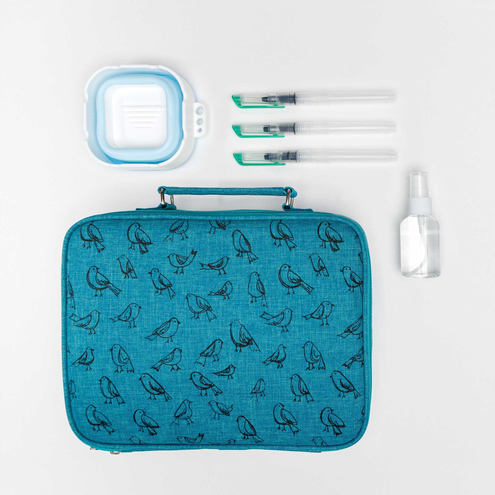 Large travel pack with teal bird print teal fabric, collapsible container,  three water brushes and travel spray bottle on a white background