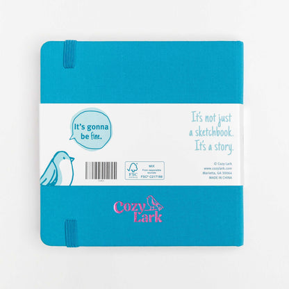 Back view of teal cloth hard cover travel notebook with bellyband and Cozy Lark logo embossed in pink centered near the bottom edge on a white background.