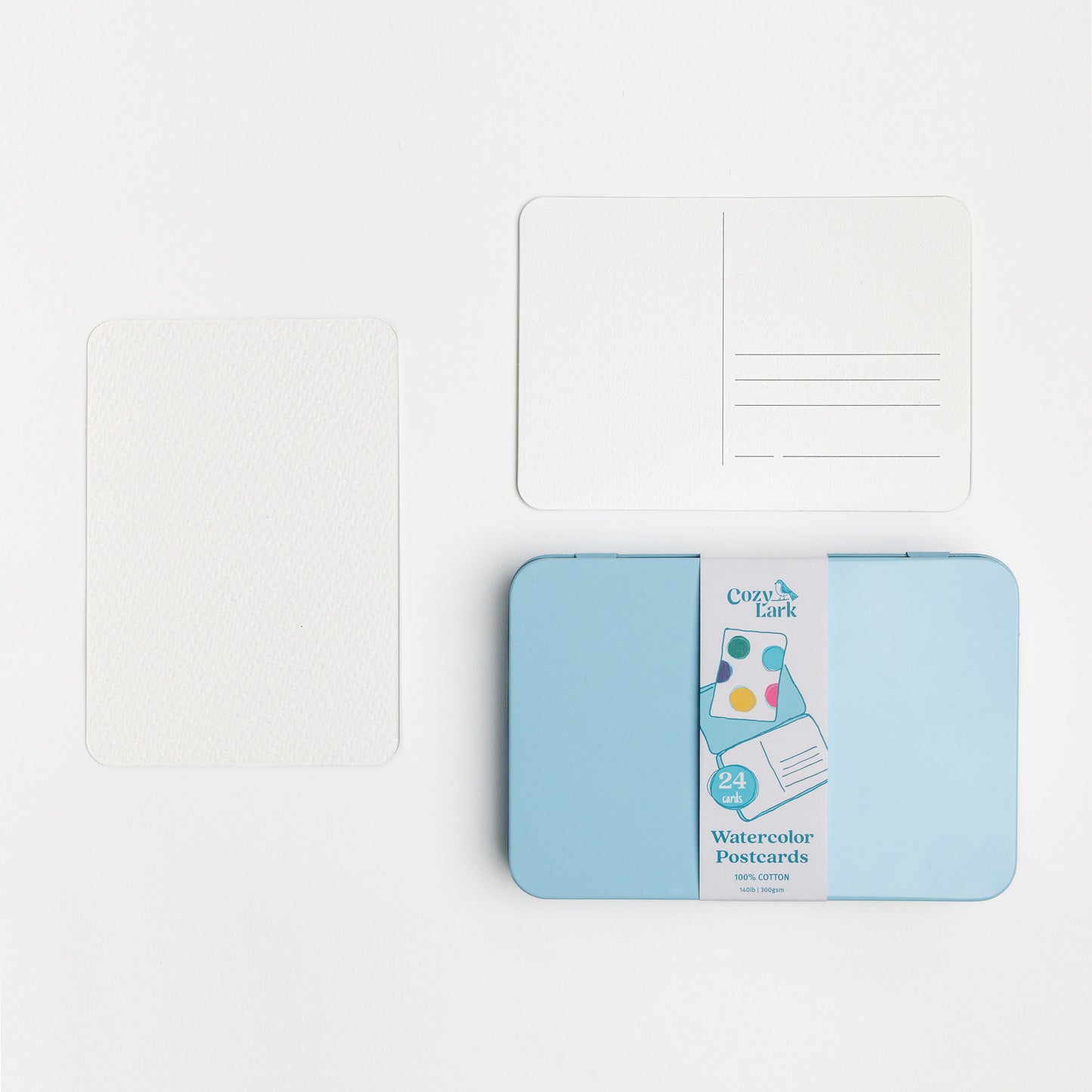 Pack of watercolor postcards with a blue tin and showing the front and back of the blank postcards.
