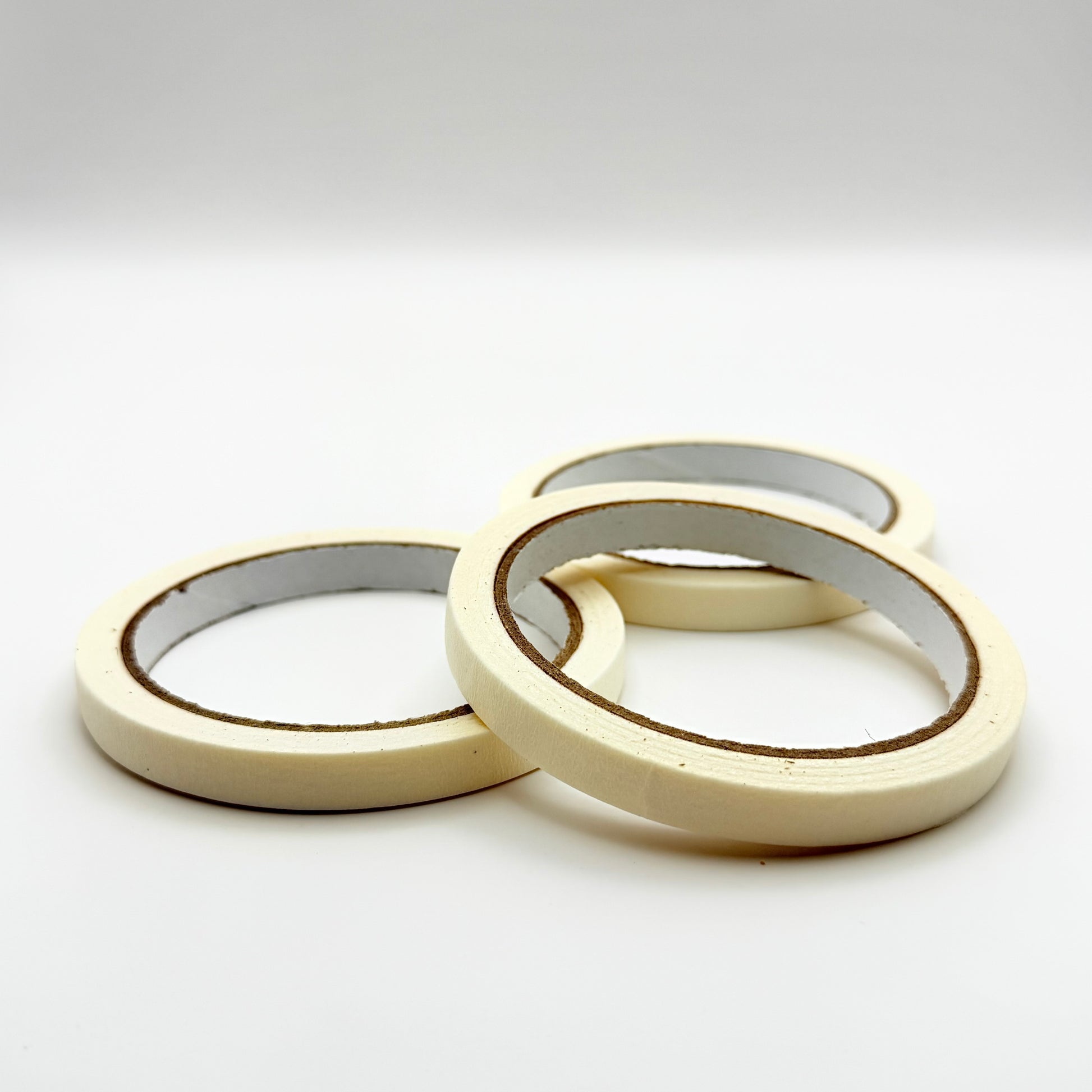 Three rolls of white 10mm tape on a white background