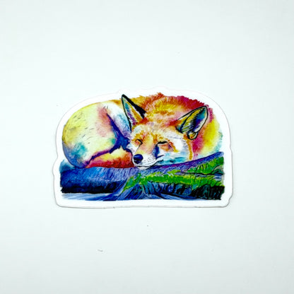 Sticker of a colorful fox sleeping on a rock with grass, on a white background